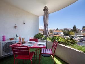 d'une table et de chaises rouges sur un balcon avec vue. dans l'établissement Apartment Le Lagon Bleu by Interhome, à Cagnes-sur-Mer