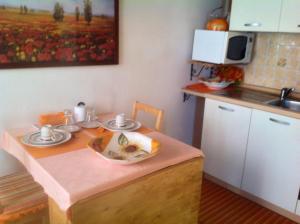 a small kitchen with a table and a sink at Appartamento Arancione in Menaggio