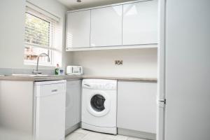 a white laundry room with a washer and dryer at Rose Cottage in Shrewsbury