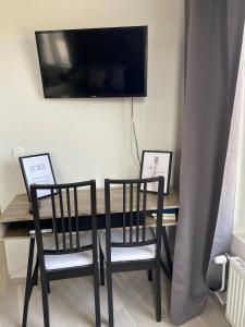 a dining room table with two chairs and a television at BOSSHOMES Apartments Espoo - Close to Helsinki and access to Airport in Espoo