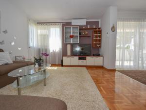 een woonkamer met een bank en een tafel bij Holiday Home Karlo by Interhome in Posedarje