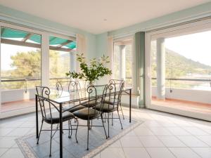 comedor con mesa, sillas y ventanas en Apartment Waterfront Oasis-2 by Interhome, en Mali Ston