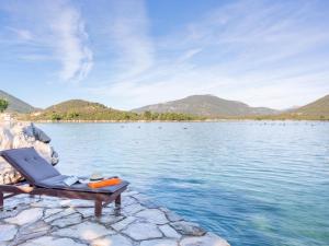 a chair sitting on the edge of a body of water at Apartment Waterfront Oasis-2 by Interhome in Mali Ston +25 photos