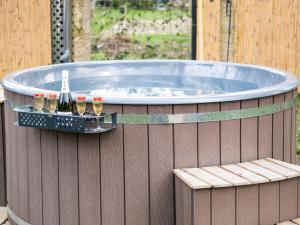 a hot tub with drinks and a bench on a fence at Holiday Home Coco Luxury Home by Interhome in Ewijk