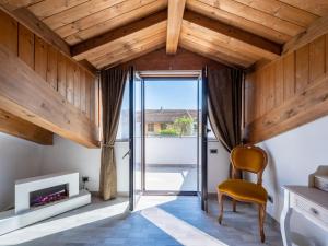 una camera con soffitti in legno, una sedia e un camino di Holiday Home Raggio di Sole by Interhome a Pontestura