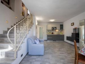 sala de estar con silla azul y escalera en Holiday Home Raggio di Sole by Interhome, en Pontestura