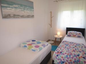 a small bedroom with two beds and a lamp at Apartment Tino-3 by Interhome in Sukošan