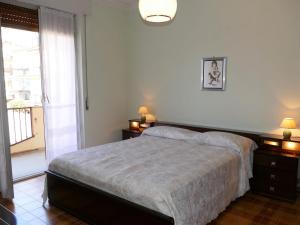 1 dormitorio con 1 cama con 2 mesitas de noche y una ventana en Apartment Rosina by Interhome, en Santo Stefano al Mare