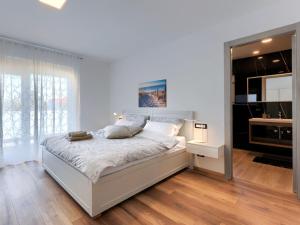 a white bedroom with a bed and a mirror at Holiday Home Villa Dora by Interhome in Pula