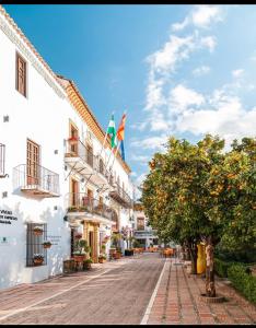マルベーリャにあるApartamento Plaza de los Naranjosの橙の木や建物のある町の通り