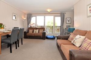 a living room with a couch and a table at Blairlagan Lodge in Hunters Quay +18 photos