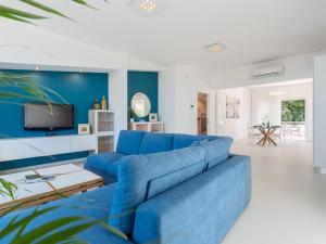 een blauwe bank in een woonkamer met een tv bij Apartment Quirat Superior by Interhome in Terrasini
