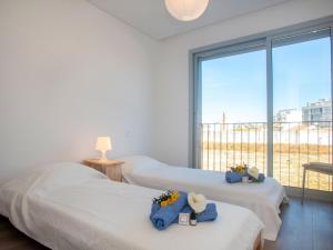 a bedroom with three beds and a large window at Apartment Montijo by Interhome in Montijo
