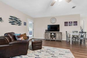 a living room with a leather couch and a table at Gulf Brz-Beaches-Dwntwn PNS-Pet Friendly-Canal in Gulf Breeze