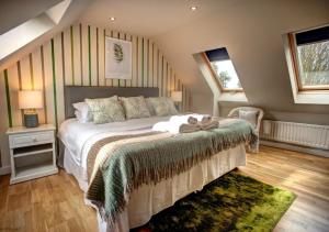 um quarto com uma cama com uma parede com riscas verdes em Dairy Three em Embleton