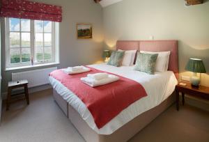 a bedroom with a large bed with two towels on it at The Groom's Flat in Leominster