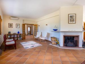 ein Wohnzimmer mit einem Kamin und Stühlen in der Unterkunft Holiday Home Vista Panorâmica- Herdade de Montalvo by Interhome in Alcácer do Sal