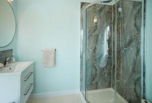 a bathroom with a shower with a glass door at Evenwood Gables in Kenley
