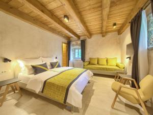 a bedroom with a large bed and a yellow couch at Holiday Home Jerini The Barn by Interhome in Vrh
