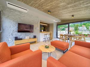 a living room with orange furniture and a stone wall at Holiday Home Jerini The Barn by Interhome in Vrh