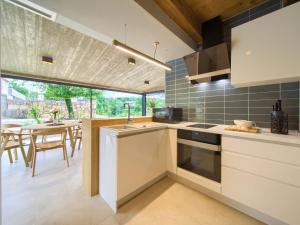 a kitchen with a large window and a table with chairs at Holiday Home Jerini The Barn by Interhome in Vrh +13 photos