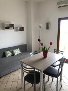 een woonkamer met een tafel en een bank bij Mini appartamento in campagna in Castagneto Carducci
