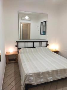 een slaapkamer met een groot bed en een spiegel bij Mini appartamento in campagna in Castagneto Carducci