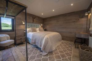 a bedroom with a bed in a room with wooden walls at Mallard House Lodge in Culgaith