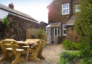 a patio with a table and chairs in front of a building at The Old Ale House in Craster