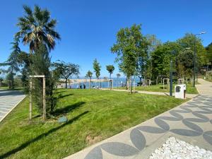 een park met een palmboom en het strand bij Alarga Premier Hotel in Trabzon