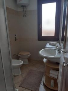 聖維托羅卡波的住宿－Relax Apartment in San Vito，一间带水槽和卫生间的浴室以及窗户。