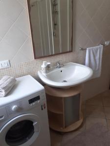 uma casa de banho com uma máquina de lavar roupa e um lavatório em Relax Apartment in San Vito em San Vito lo Capo