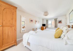 a bedroom with two white beds and a large window at Seafarers in Seahouses