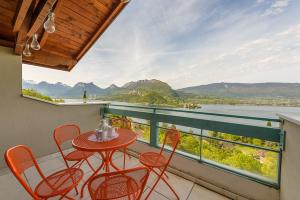 a balcony with a table and chairs and a view of the water at L'Hermitage, 4 appartements avec terrasse, vue lac, parking et PISCINE, LLA Selections by Location Lac Annecy in Talloires