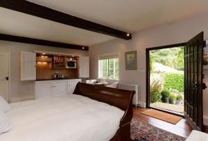 a bedroom with a large bed and a kitchen at Ayres End Studio in Kersey