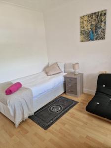 um pequeno quarto com uma cama e uma cadeira em Spacious Luxurious Serviced Accomodation em Doncaster
