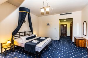 a hotel room with a large bed and a desk at Hotel Grand Vígľaš in Zvolen