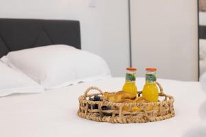 Una cesta de pan y dos botellas de zumo en una cama. en Charming apartment completely renovated Boulogne Billancourt, en Boulogne-Billancourt