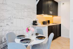 a dining room with a white table and chairs at Charming apartment completely renovated Boulogne Billancourt in Boulogne-Billancourt