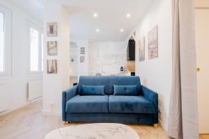 un sofá azul en una sala de estar blanca en Charming apartment completely renovated Boulogne Billancourt, en Boulogne-Billancourt