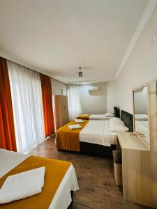 a hotel room with two beds and a mirror at Alanya Queen Apart Otel in Alanya