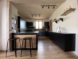 a kitchen with two stools and a bar in a room at Hostellerie des Princes-Evêques - La Fleur de Lys in Porrentruy