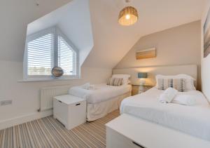a bedroom with two beds and a window at Smugglers Hide in Beadnell