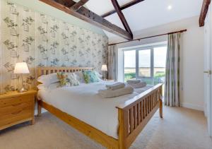 a bedroom with a large bed and a large window at High Mill in Beadnell
