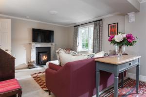 a living room with a couch and a fireplace at Laundry Cottage in Pickmere