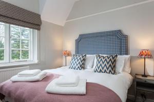 a bedroom with a large bed with two white towels on it at Laundry Cottage in Pickmere