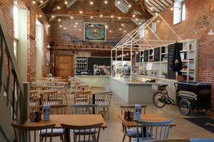 a restaurant with wooden tables and chairs and a counter at Laundry Cottage in Pickmere