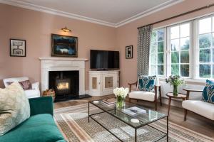a living room with a fireplace and a tv at East House in Pickmere