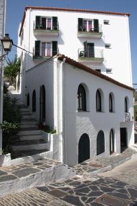 un edificio blanco con escaleras y balcones. en Hotel Ubaldo, en Cadaqués