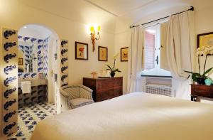 a bedroom with a white bed and a window at Le Sirenuse in Positano